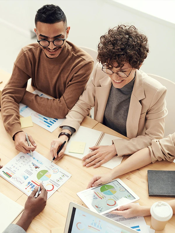 Founders and advisors collaborating over charts and data, representing the PitchTank AI community focused on transparent, AI-backed startup evaluation.