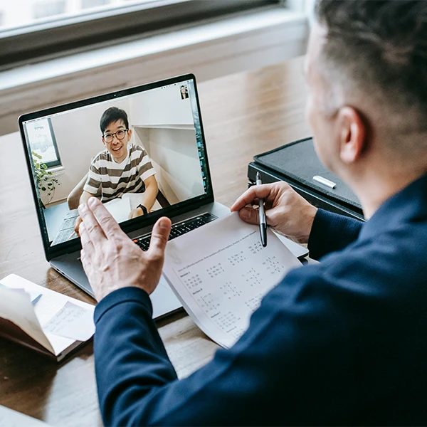 An advisor meeting with a founder over a virtual video call, discussing documents and strategy as part of the PitchTank AI founder community.
